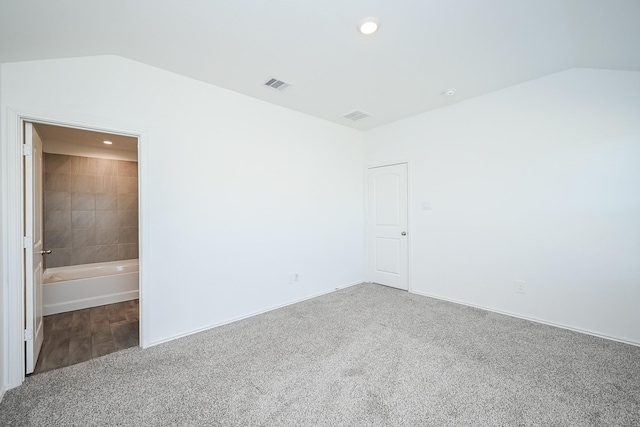 carpeted spare room featuring lofted ceiling, visible vents, and recessed lighting