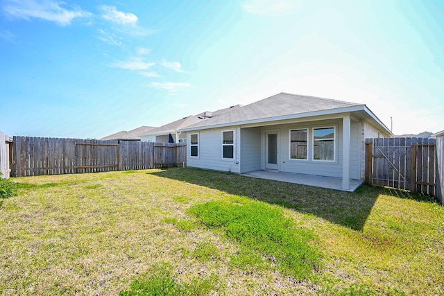 back of property with a fenced backyard, a lawn, and a patio