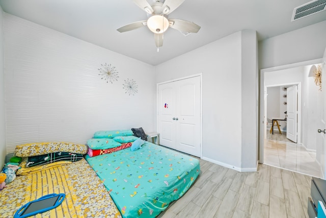 bedroom featuring a ceiling fan, light wood-type flooring, visible vents, and baseboards