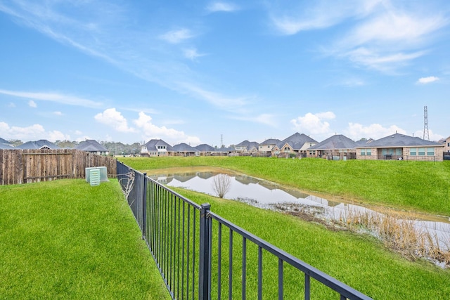 view of yard with a water view, a fenced backyard, and a residential view