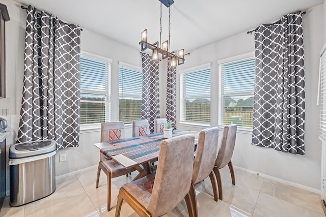 dining space with light tile patterned floors, baseboards, and a notable chandelier