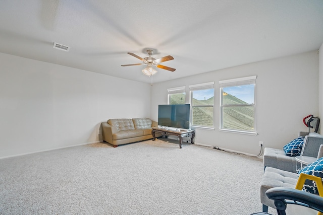 carpeted living room with ceiling fan, visible vents, and baseboards