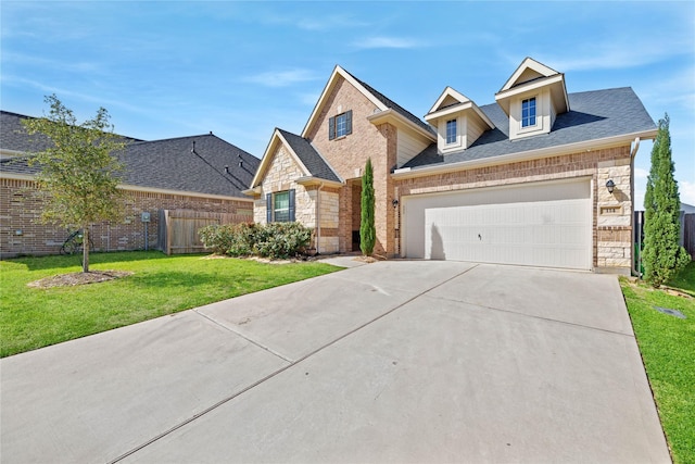 view of front of house featuring driveway, stone siding, fence, a front yard, and brick siding