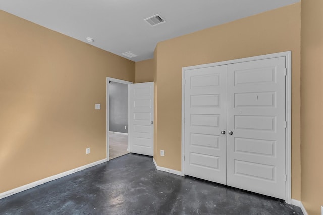 unfurnished bedroom featuring baseboards, a closet, visible vents, and concrete flooring