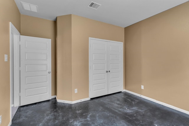 unfurnished bedroom featuring concrete flooring, a closet, visible vents, and baseboards