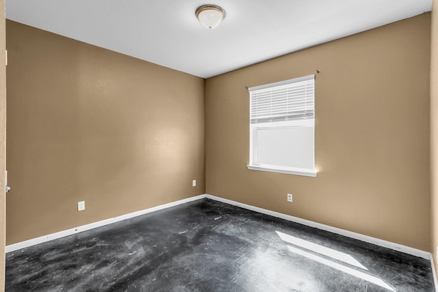 unfurnished room with concrete floors and baseboards