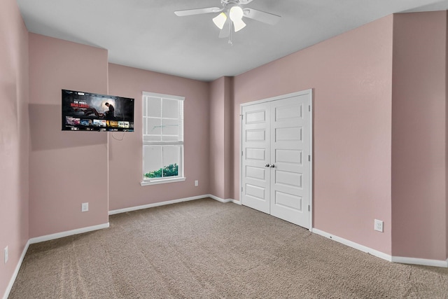 unfurnished bedroom featuring carpet floors, baseboards, and a ceiling fan