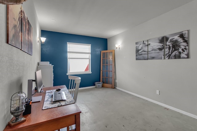 office area with baseboards and concrete flooring