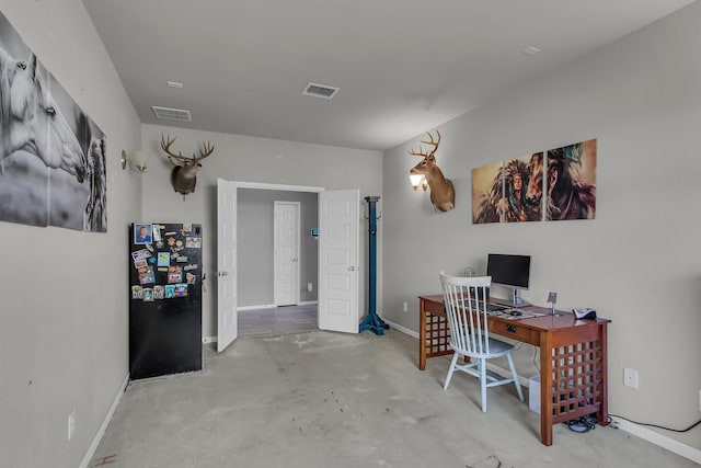 home office featuring visible vents, concrete floors, and baseboards