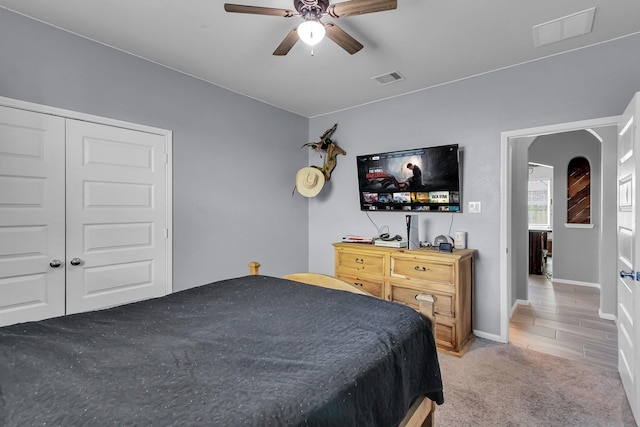 bedroom featuring light carpet, ceiling fan, visible vents, and baseboards