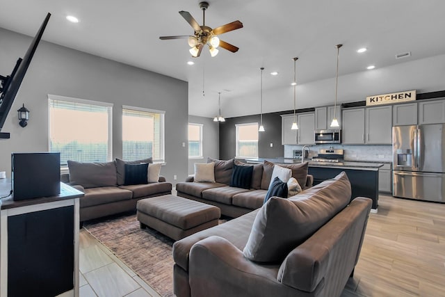 living room featuring a ceiling fan, recessed lighting, and light wood-style floors