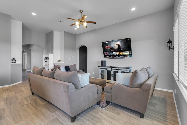 living room with arched walkways, recessed lighting, visible vents, ceiling fan, and baseboards