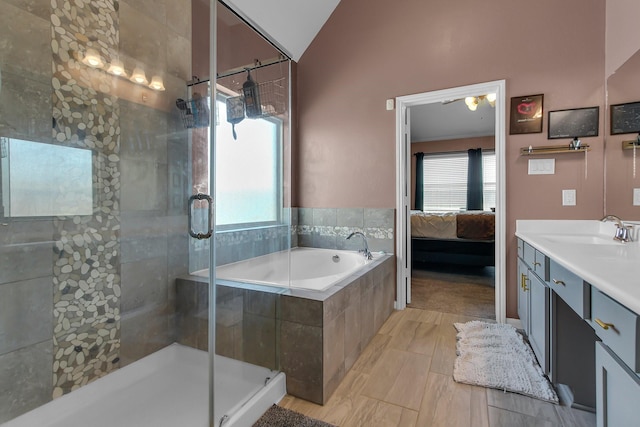 ensuite bathroom featuring lofted ceiling, a garden tub, a shower stall, and ensuite bath