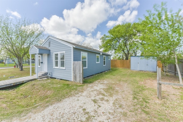 2430 5th Ave N, Texas City, TX 77590 - view of side of home with fence, entry steps, a lawn, a storage shed, and an outbuilding