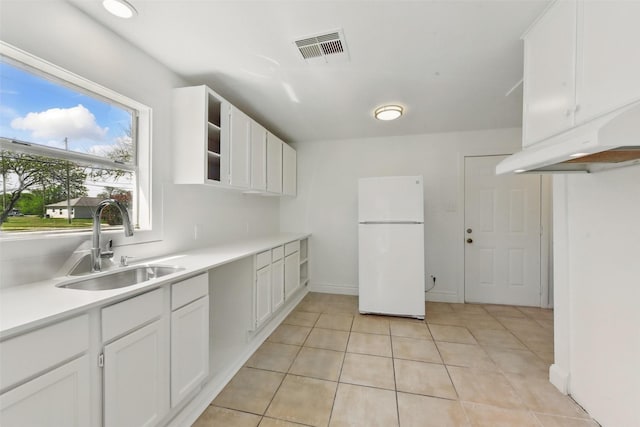 2430 5th Ave N, Texas City, TX 77590 - kitchen with visible vents, freestanding refrigerator, a sink, light countertops, and white cabinetry