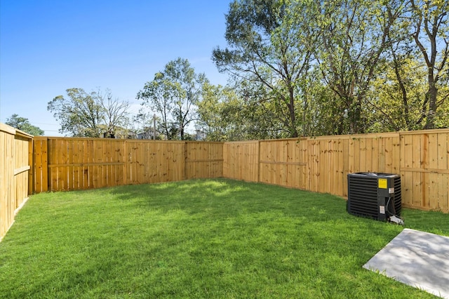 view of yard with a fenced backyard and central AC