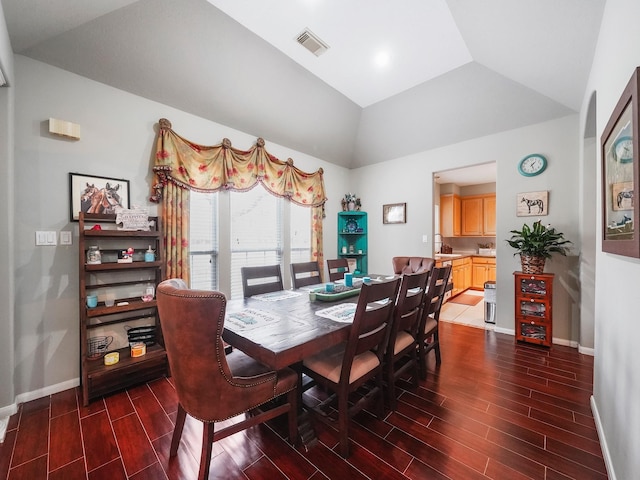 dining area featuring wood finish floors, visible vents, vaulted ceiling, and baseboards