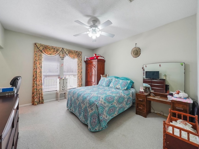 bedroom with a textured ceiling, ceiling fan, baseboards, and light colored carpet