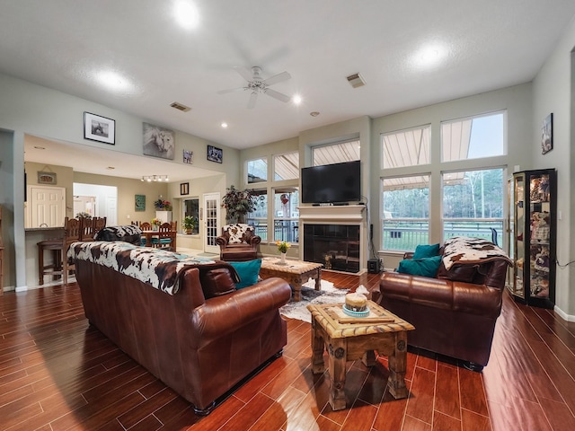 living area featuring visible vents, a tiled fireplace, and wood finish floors