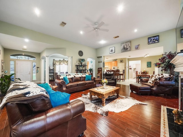 living room with a healthy amount of sunlight, ornate columns, visible vents, and dark wood-style floors