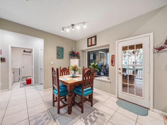 dining room featuring washer / dryer, baseboards, and light tile patterned floors