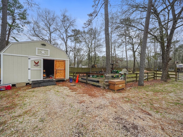 view of yard featuring a storage unit, fence, and an outdoor structure