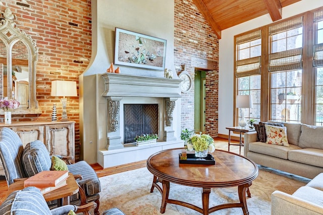 living room featuring beam ceiling, a fireplace with raised hearth, light wood-style flooring, wood ceiling, and high vaulted ceiling