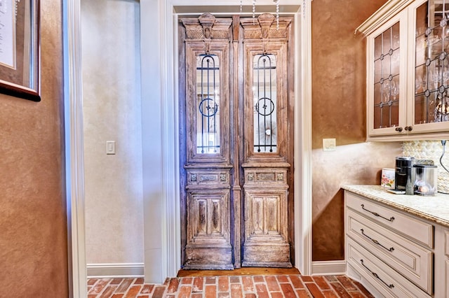 interior space featuring brick floor and baseboards