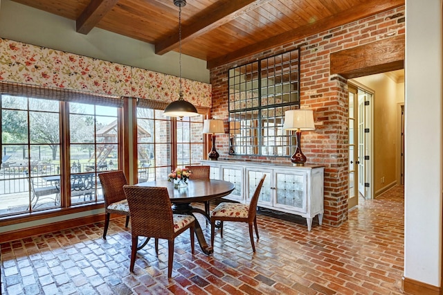 dining room featuring brick floor, wooden ceiling, baseboards, and beam ceiling