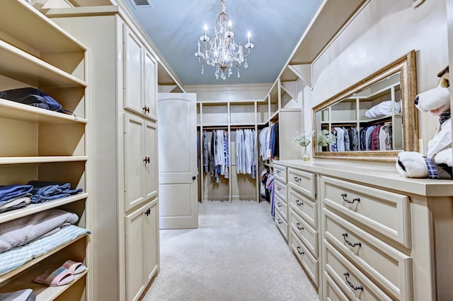 spacious closet with a chandelier and light colored carpet