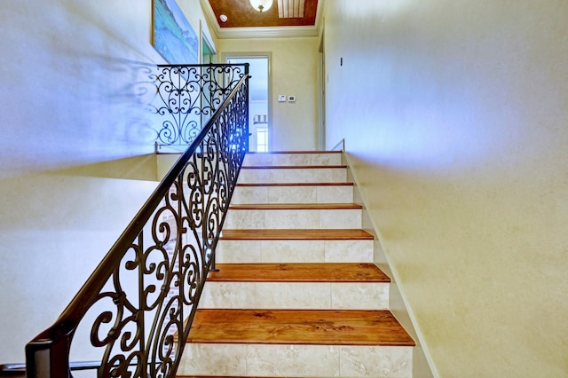 staircase featuring baseboards and crown molding