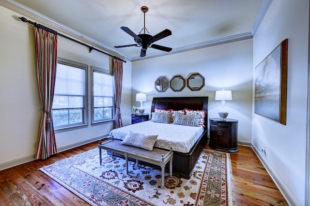 bedroom with a ceiling fan, baseboards, crown molding, and wood finished floors