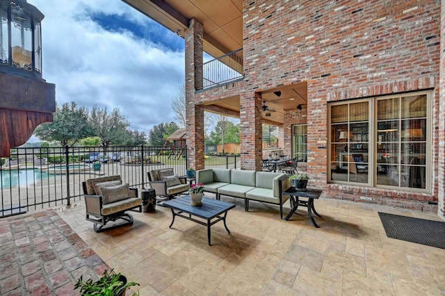 view of patio featuring a balcony, a pool with connected hot tub, fence, and an outdoor living space