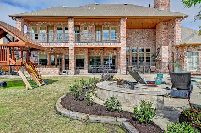 back of property with a chimney, a fire pit, a patio, and brick siding