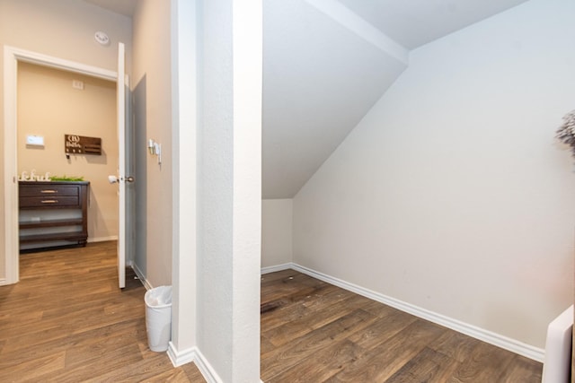 additional living space with dark wood finished floors and baseboards