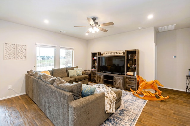 living room with dark wood finished floors, visible vents, and baseboards