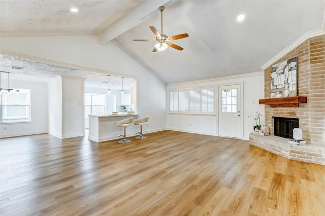 unfurnished living room with wood finished floors, a fireplace, baseboards, ceiling fan, and vaulted ceiling with beams