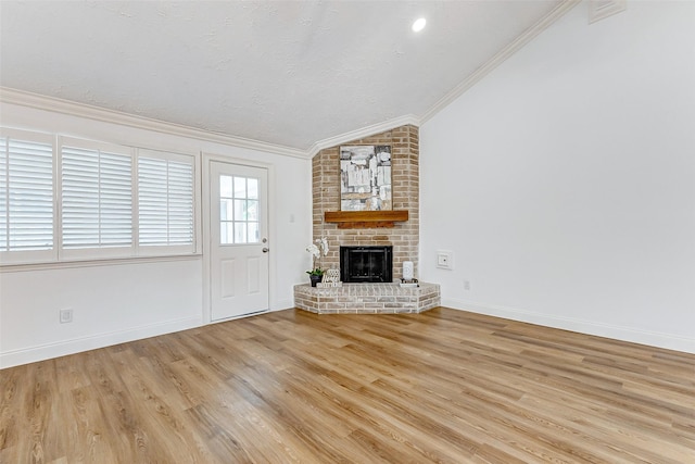 unfurnished living room featuring crown molding, lofted ceiling, wood finished floors, a fireplace, and baseboards