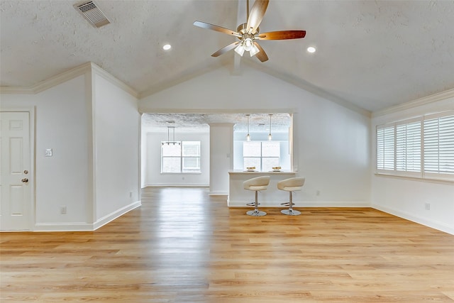 living room featuring visible vents, a ceiling fan, light wood-type flooring, and ornamental molding