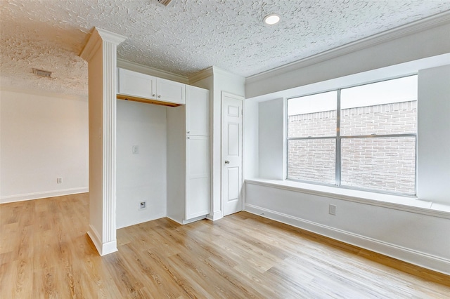 unfurnished bedroom featuring visible vents, crown molding, a closet, light wood-style floors, and a textured ceiling
