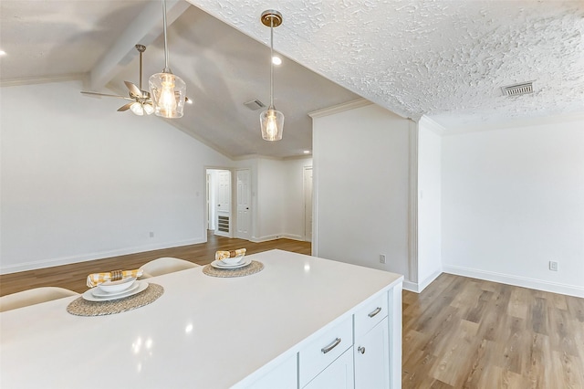 kitchen featuring visible vents, pendant lighting, ceiling fan, and wood finished floors