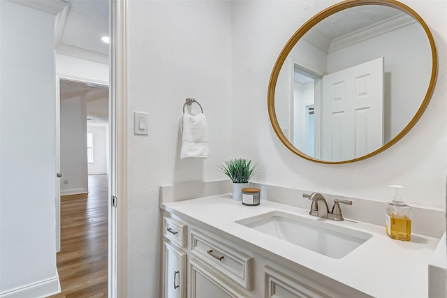 bathroom featuring vanity, ornamental molding, and wood finished floors