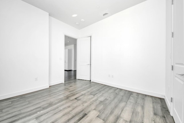 unfurnished room featuring visible vents, light wood-style flooring, and baseboards