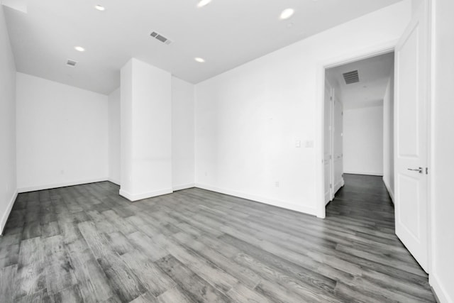 unfurnished room with baseboards, visible vents, wood finished floors, and recessed lighting