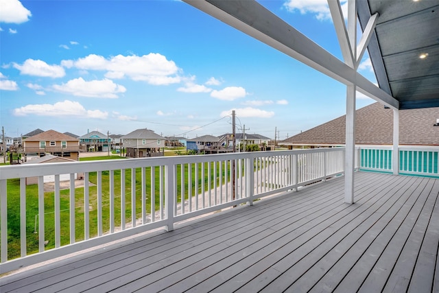 wooden deck featuring a residential view and a yard