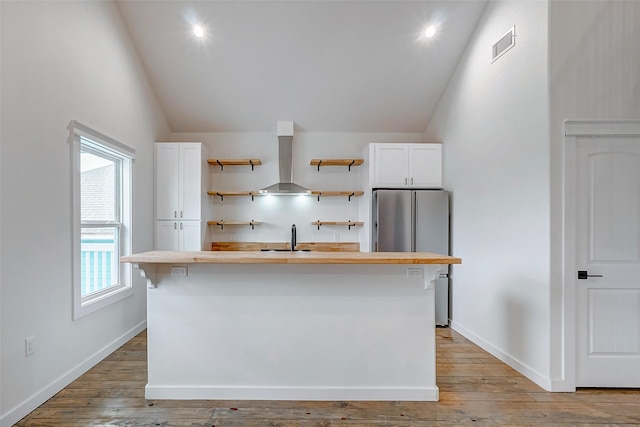 kitchen featuring open shelves, ventilation hood, a kitchen island with sink, and white cabinets