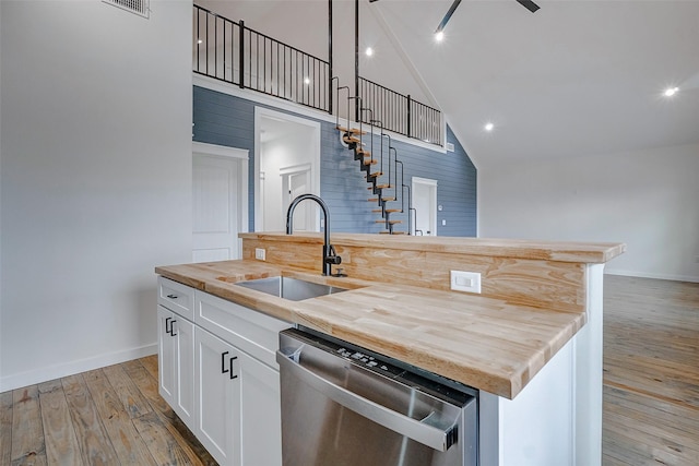 kitchen with dishwasher, a sink, a center island with sink, and white cabinetry