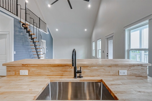 kitchen featuring wood counters, high vaulted ceiling, a sink, and recessed lighting