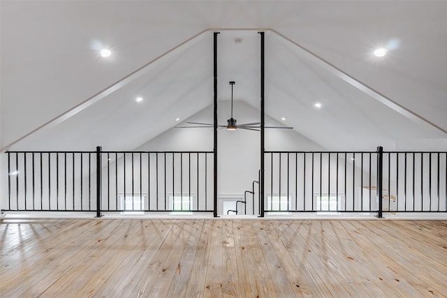 unfurnished room with light wood-style floors, vaulted ceiling, and a ceiling fan