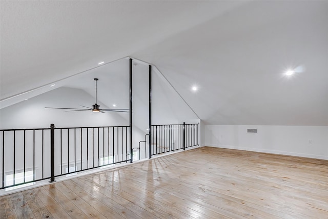 additional living space featuring light wood finished floors, visible vents, vaulted ceiling, and a ceiling fan